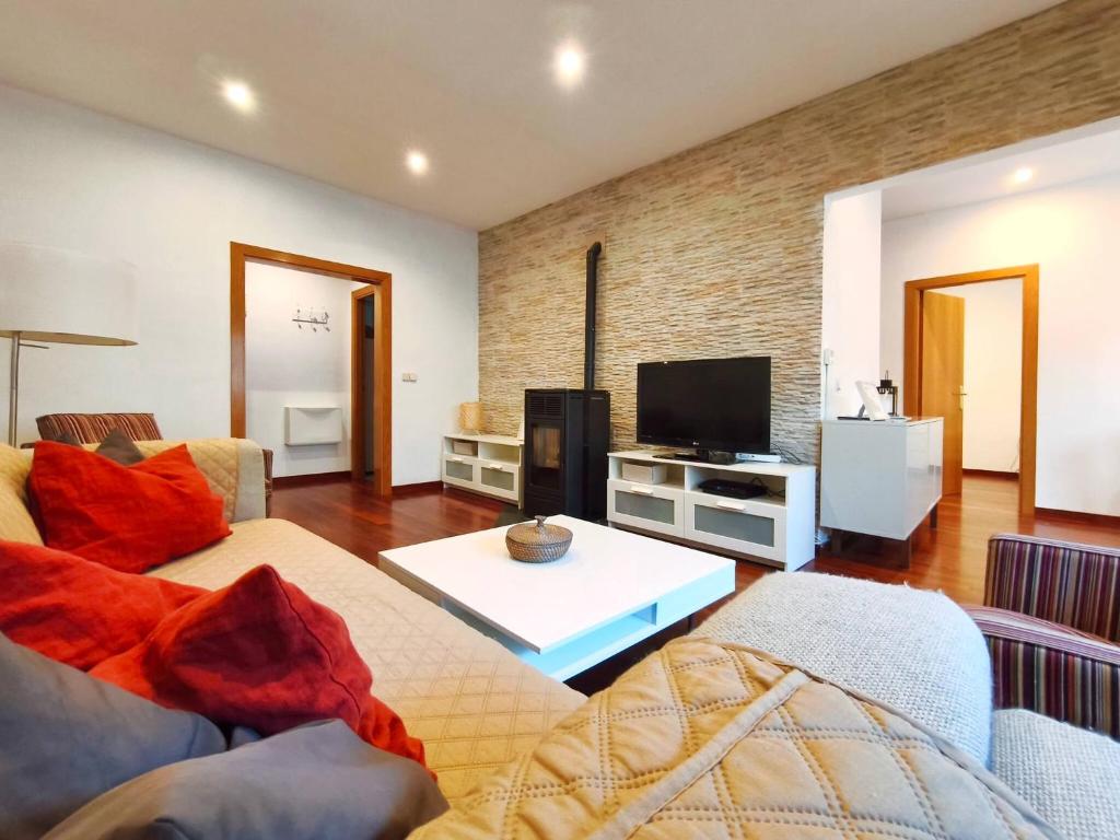 a living room with a couch and a tv at Apt 2 hab Camprodon, chimenea, terraza, céntrico in Camprodon