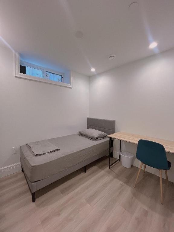 a bedroom with a bed and a desk and a table at Claire House in Vancouver