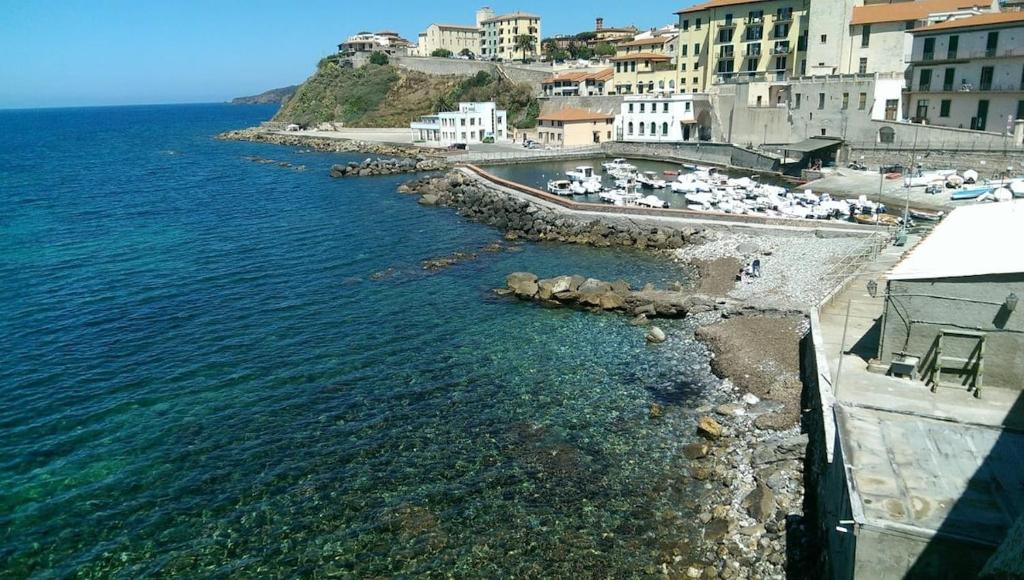 a view of a beach with buildings and the ocean at Outside the Townhall in Piombino