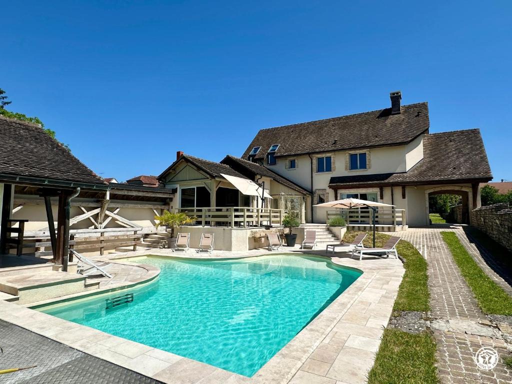 a swimming pool in the backyard of a house at Gîte des Pruniers in Saint-Germain-le-Rocheux