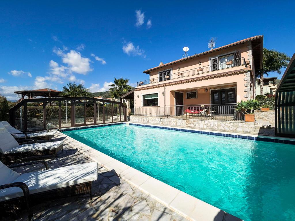 a swimming pool in front of a house at Villa Di Marmo in Trappitello