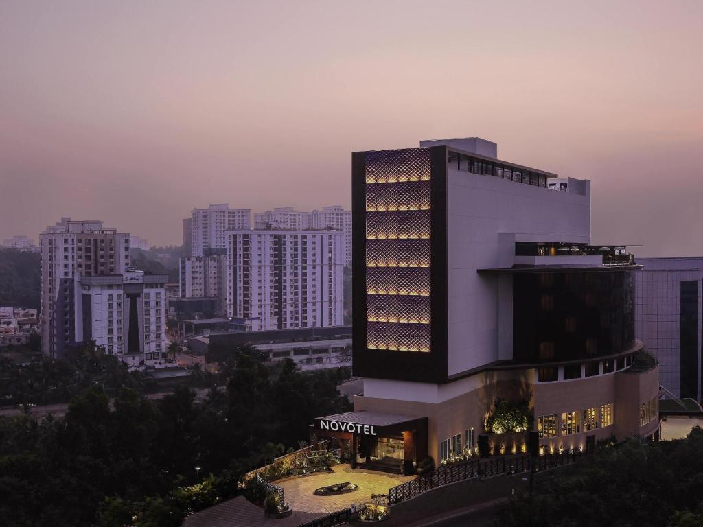 a hotel building with lights on it in a city at Novotel Kochi Infopark in Cochin
