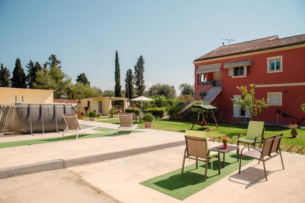 a patio with chairs and a table and a house at Villa Vasiliki in Lefkimmi