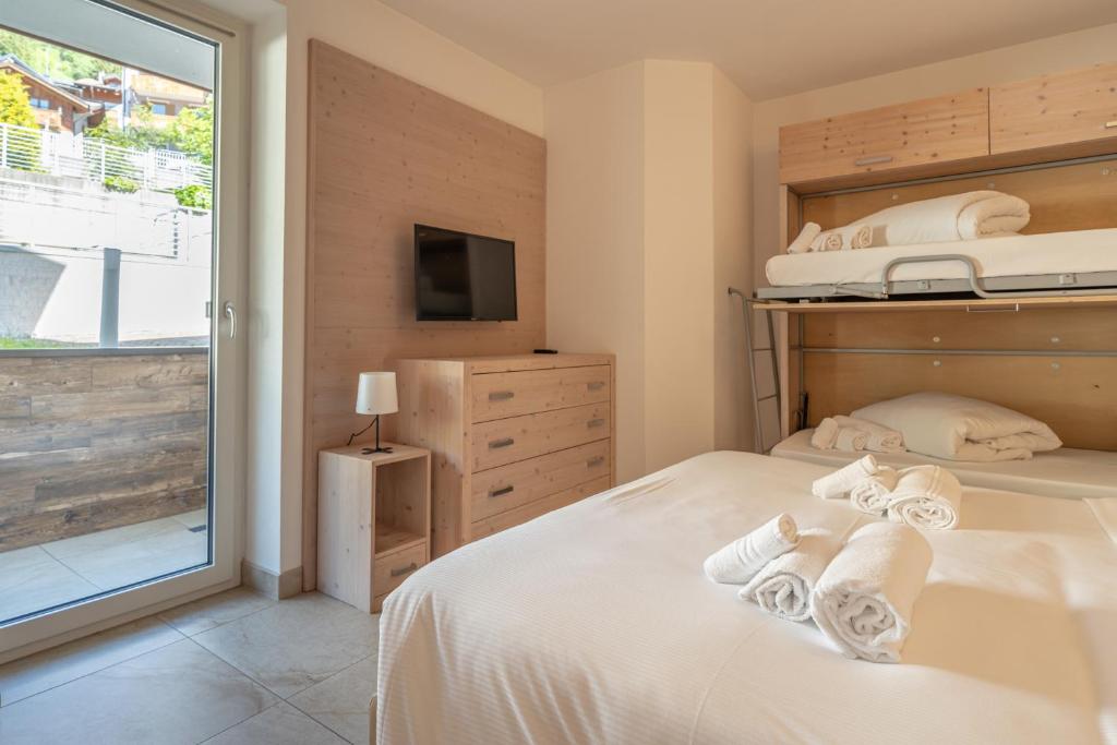 a bedroom with a bed with towels on it at Molveno Garden Suite in Molveno