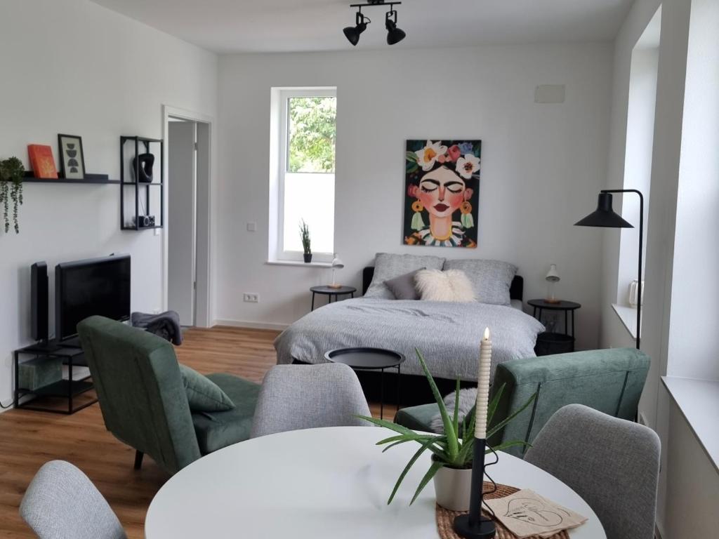 a living room with a bed and a table and chairs at 1-Zimmer-Loft Casa Frida in Walldürn