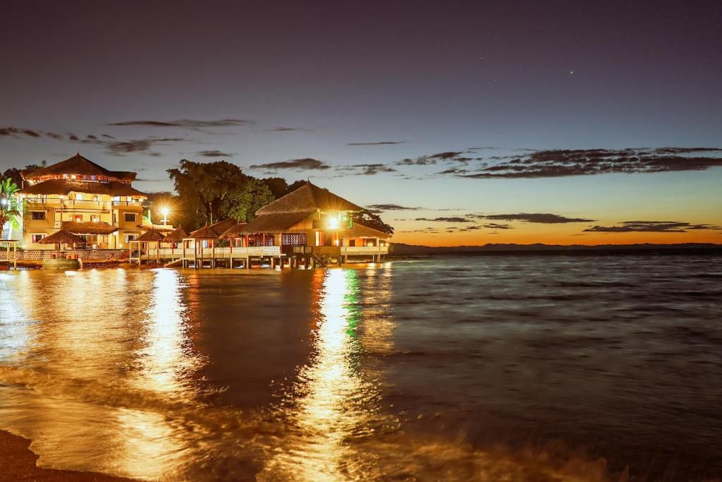 a resort on the shore of the water at night at Marionel Hôtel in Ampilahoa