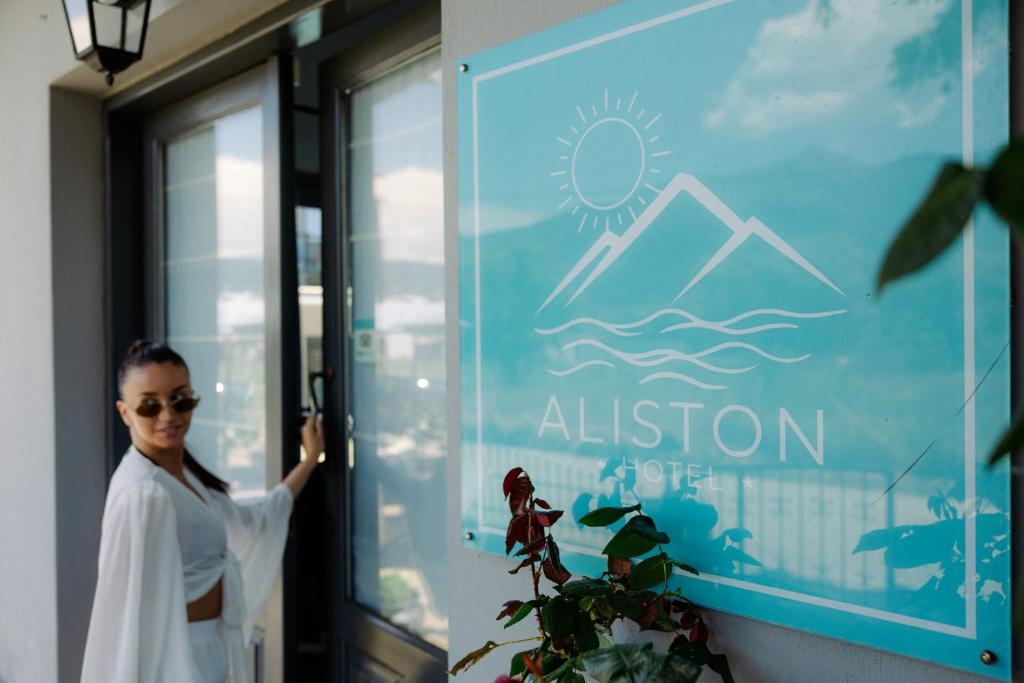 a woman standing in front of a glass door at Aliston Hotel Thassos in Skala Potamias