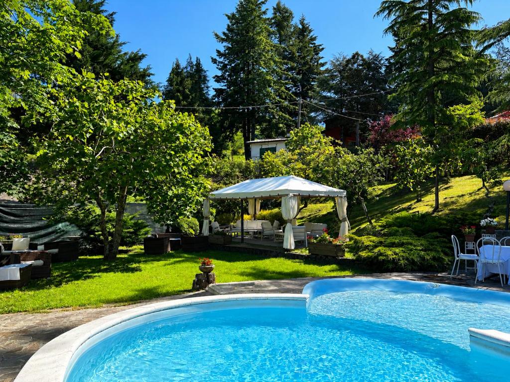 a swimming pool in a yard with a gazebo at Cuccaro Club - Val di Vara e Cinque Terre in Rocchetta di Vara