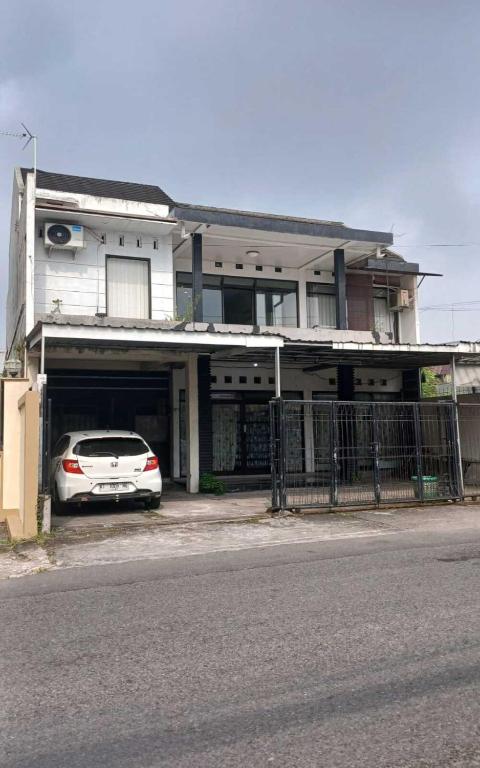 a white car parked in front of a house at NN Kost 009 Manage by Omm Kost in Beran-kidul
