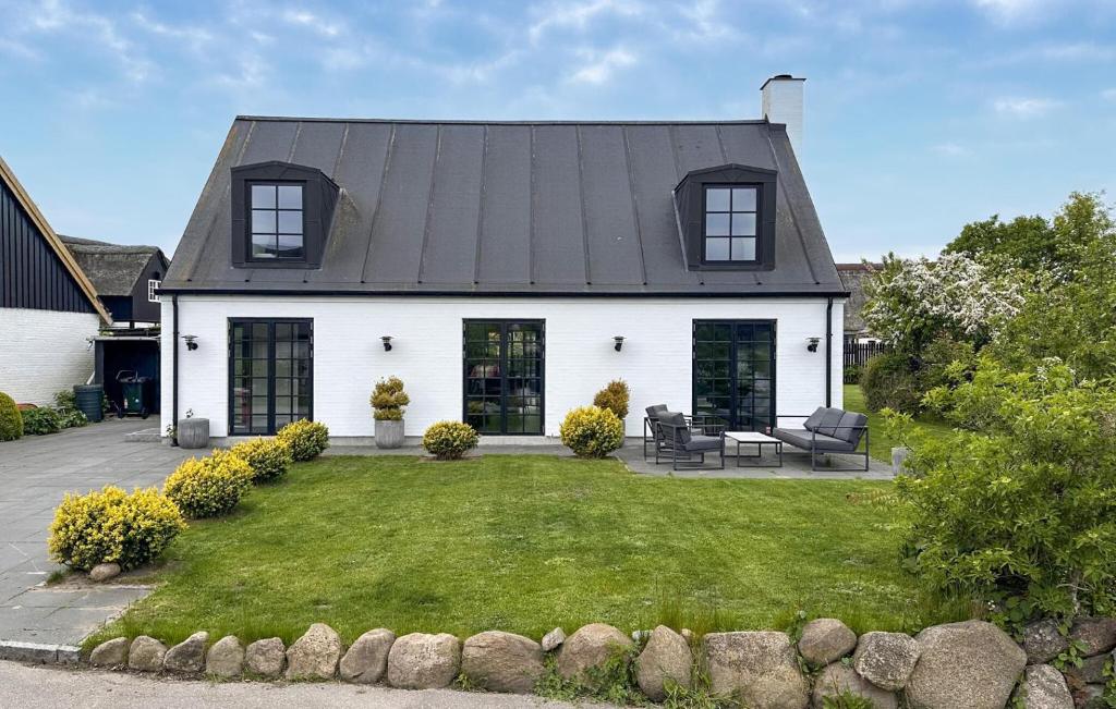 a white house with a black roof and a yard at Gorgeous Home In Samsø With Wifi in Nordby
