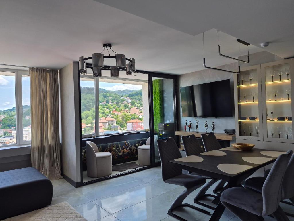 a dining room with a table and chairs and a large window at The View -Balkan Tower безплатно паркомясто in Gabrovo