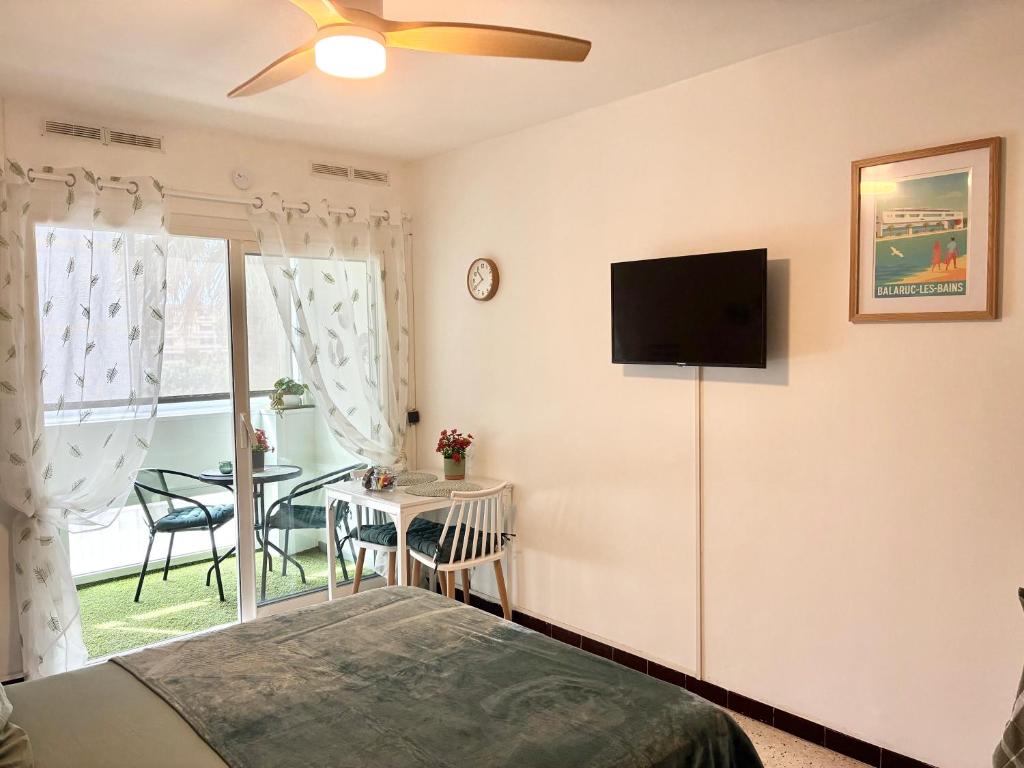 a bedroom with a bed and a television on a wall at Studio 25m2 à deux pas des thermes in Balaruc-les-Bains