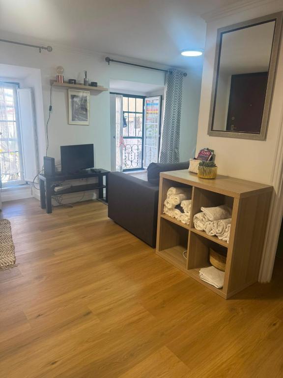a living room with a couch and a television at Pátio de Alfama in Lisbon