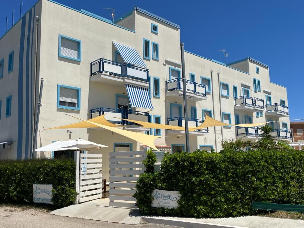 a large apartment building with an umbrella next to it at Campitur in Campomarino