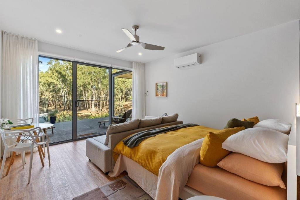 a bedroom with a bed and a sliding glass door at Tocumwal Chocolate School in Tocumwal