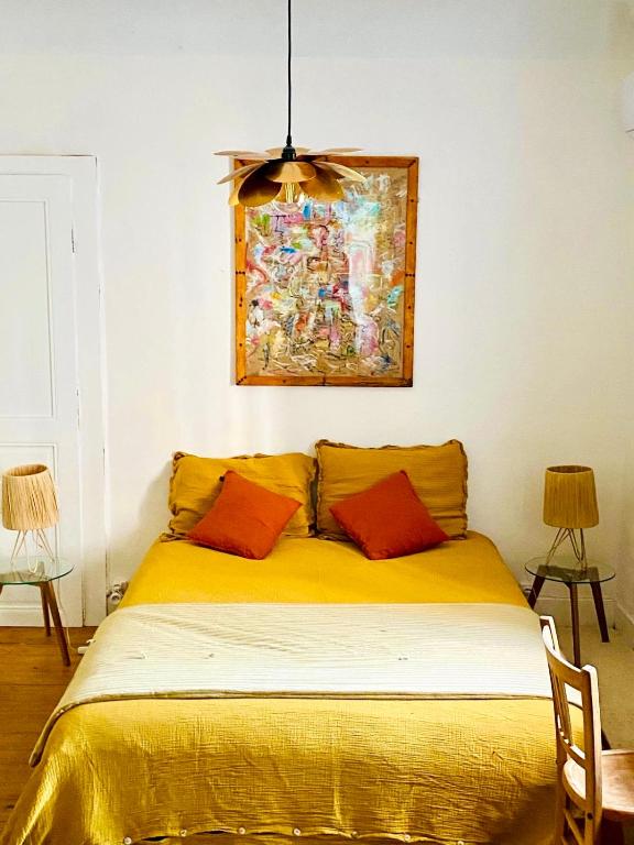 a bedroom with a yellow bed with a painting on the wall at Chambre 2 personnes Maison Saint Jean in Château-Chalon