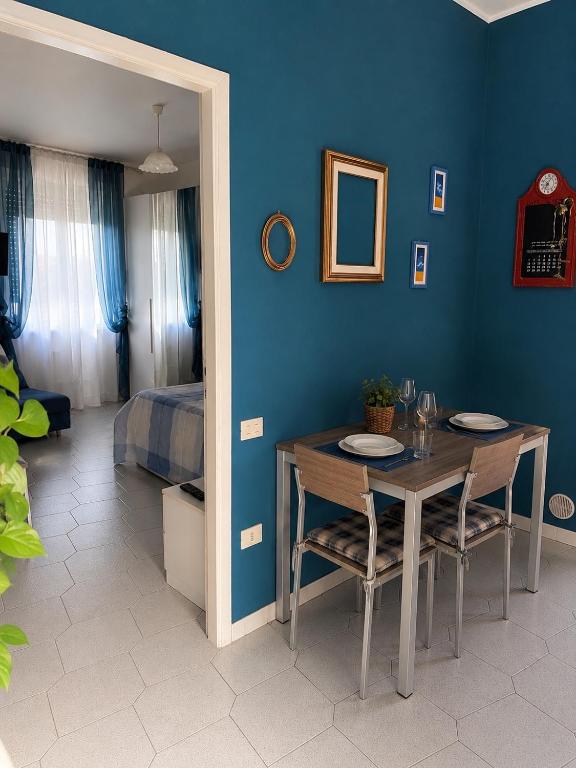 a dining room with a table and a blue wall at La casetta di Andreina in Sarzana