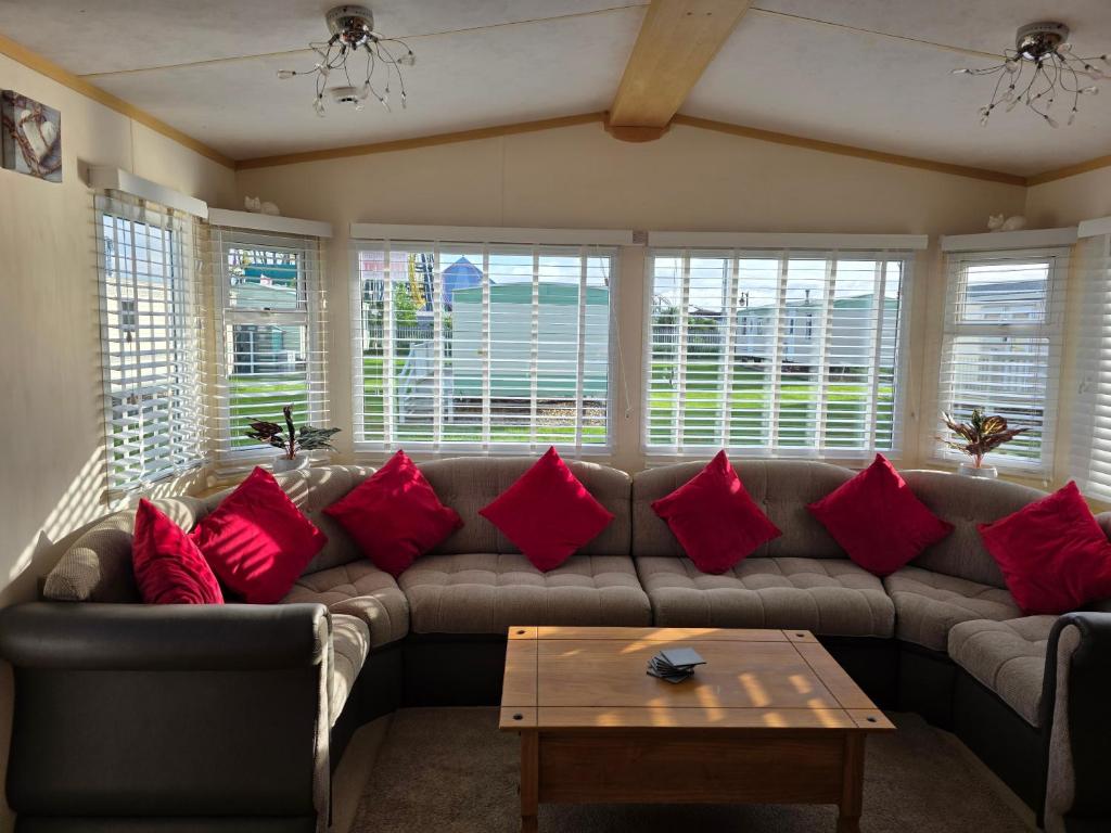 a living room with a couch with red pillows at Julie and Shaun's in Ingoldmells