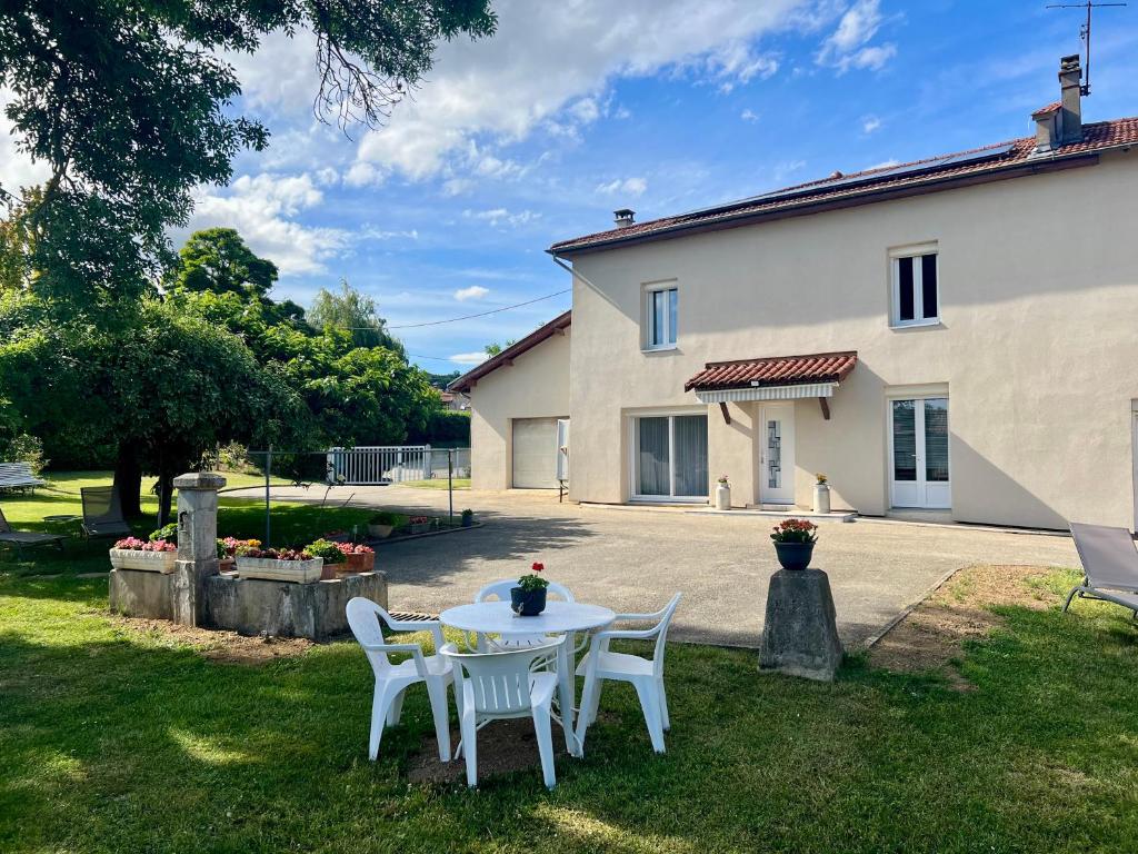 a table and chairs in front of a house at Corps de ferme à 50min de Lyon in Moissieu-sur-Dolon