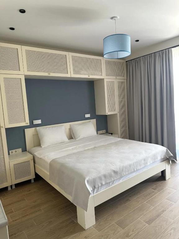 a bedroom with a large bed with a blue wall at terrace kaprovan in Urekis Sadguri