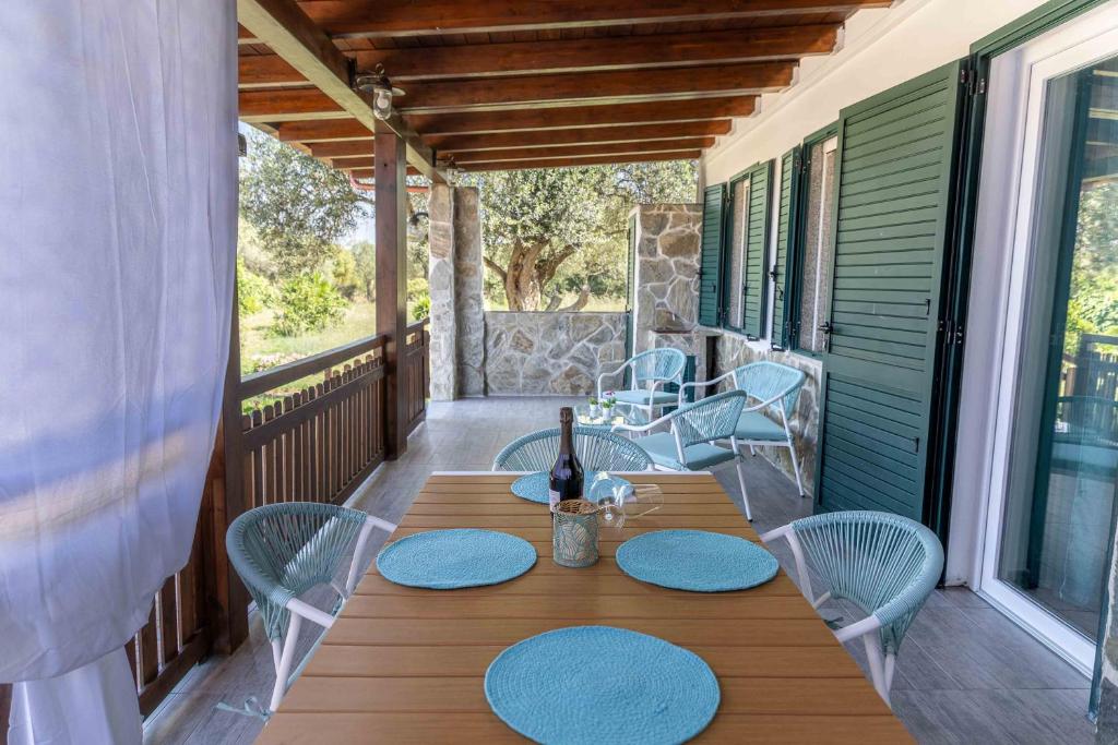 a table and chairs on a porch with a bottle of wine at Casa Turchese in Alghero