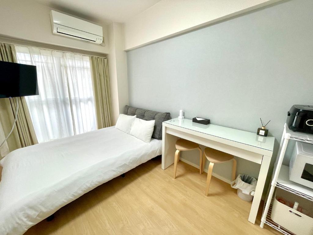 a hotel room with a bed and a desk at ベルビー川崎 in Kawasaki
