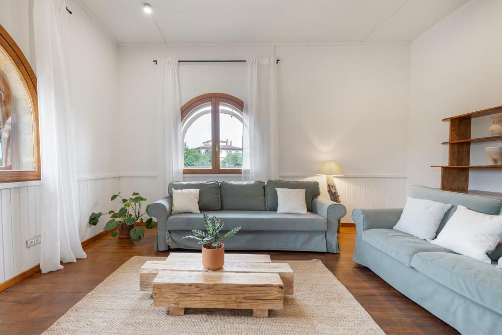 a living room with two blue couches and a coffee table at Ca la Crish in Horta de San Joan