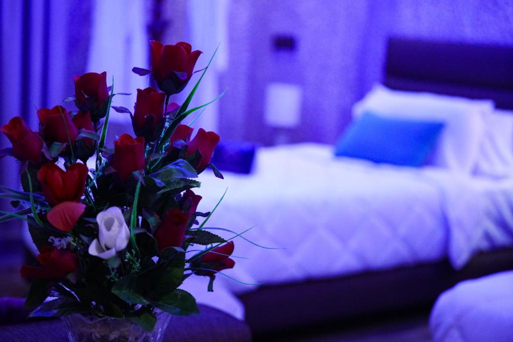 a bouquet of red roses in front of a bed at Hotel Cafe Sahariano in Smara