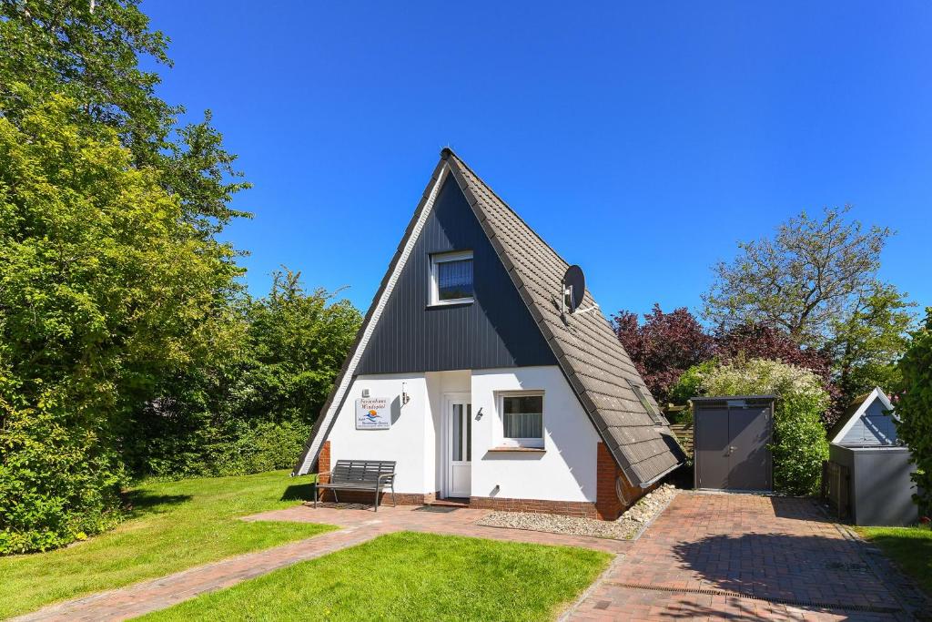 a small house with a black roof at Ferienhaus Windspiel in Neuharlingersiel