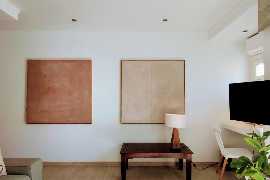 a living room with two paintings on the wall and a table at RCE Albufeira Spring, Summer & Fall in Albufeira