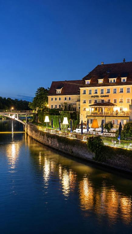 a view of a river with buildings and a bridge at Hotel NeckarOase in Lauffen am Neckar