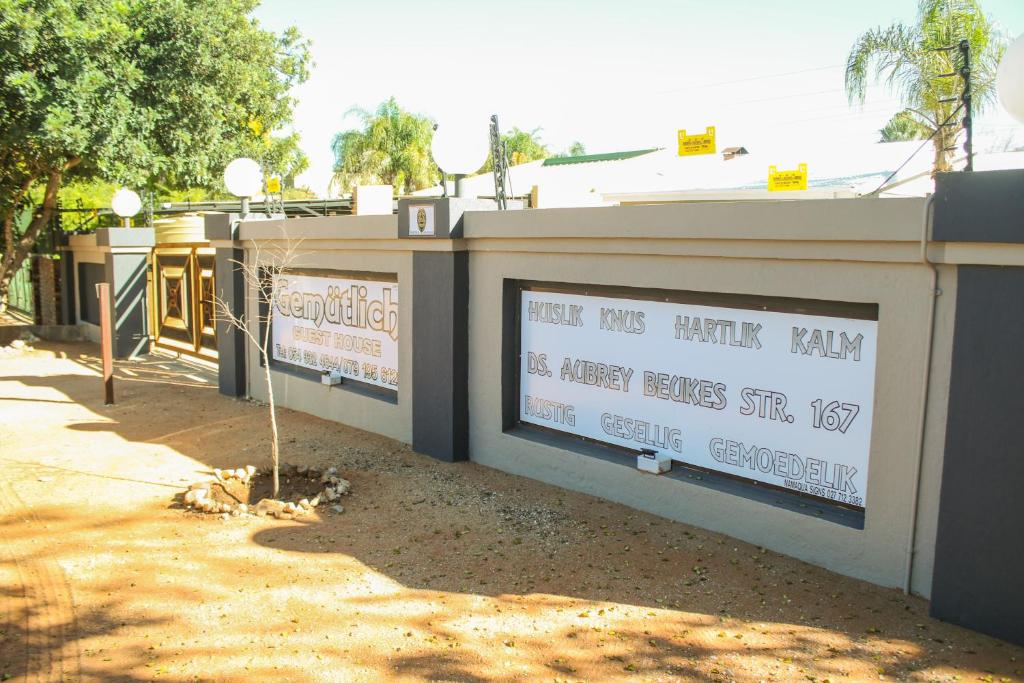 a building with a sign on the side of it at Gemutlich Guesthouse in Upington