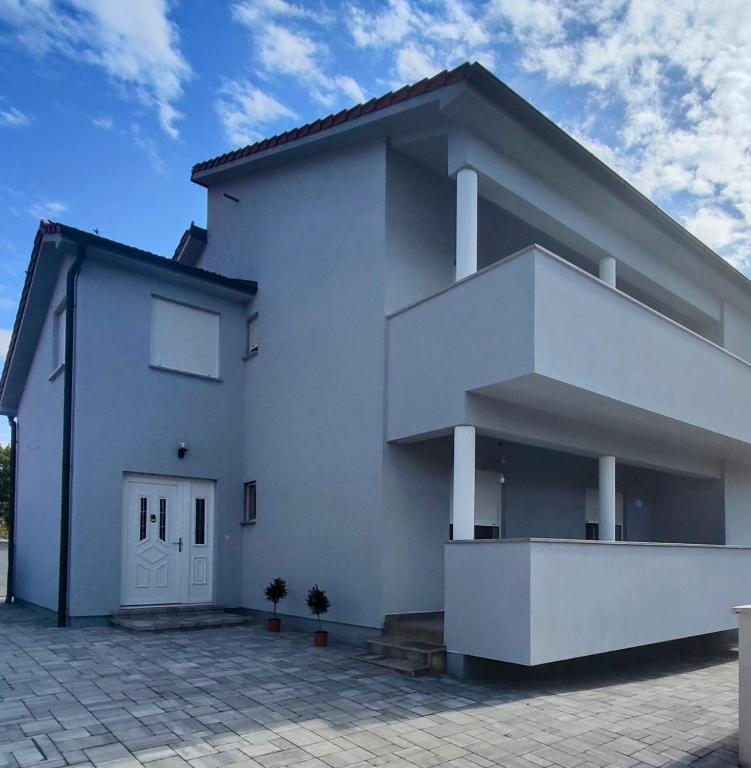 a white house with a driveway in front of it at Kata 2 in Ližnjan