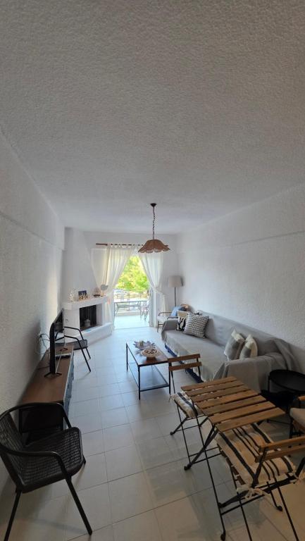 a living room with a couch and a table at Bright & Bloom maisonette in Hanioti