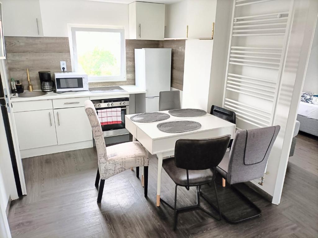 a small kitchen with a white table and chairs at Möblierte Wohnung in Flörsheim am Main