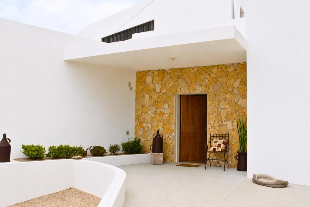 a house with white walls and a stone wall at Villa Penim - Countryside Villa with Jacuzzi, Garden with BBQ & Stunning Views in Sesimbra
