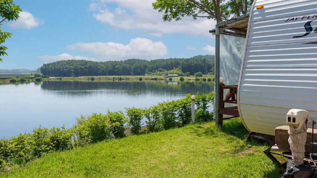 an rv is parked next to a lake at Taean Bibi ArtGlamping in Taean