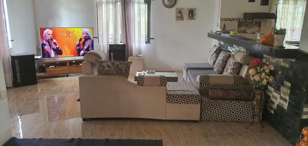 a living room with two chairs and a tv at Bethany in Riche Bois