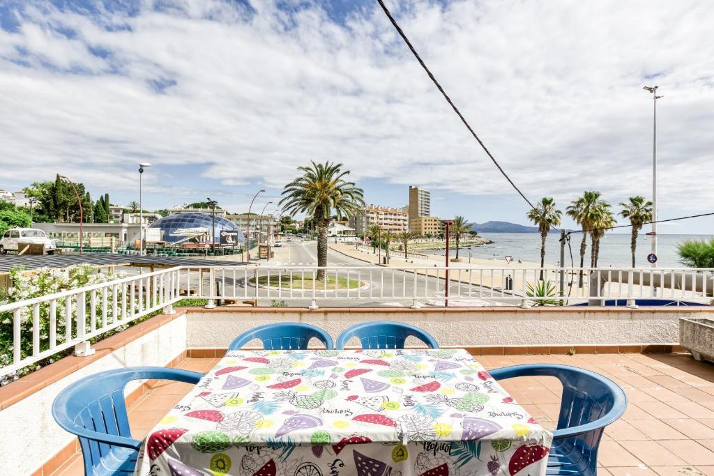a table and chairs on a balcony with a view of the ocean at Apartamento Girelle in L'Escala