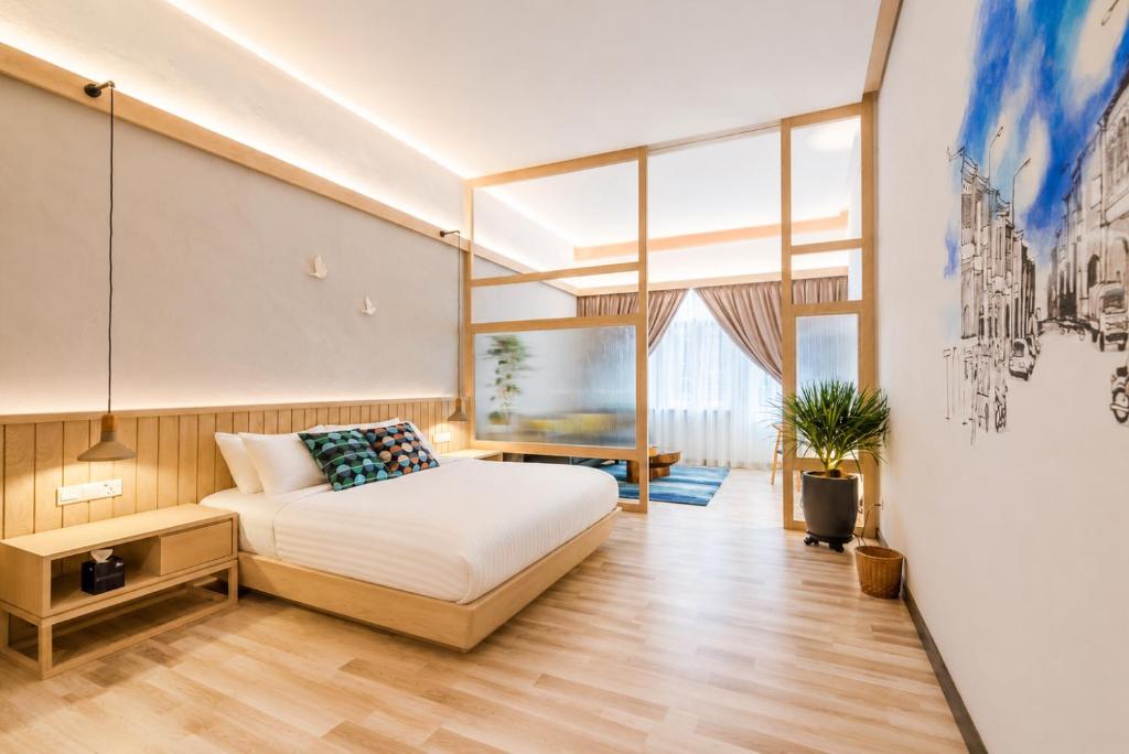a bedroom with a bed and a large window at Tien Hotel Georgetown in George Town