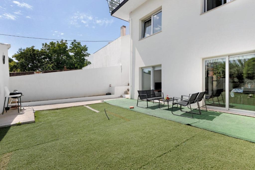 a patio with chairs and a table on a lawn at Manuel'shouse in Vila Nova de Gaia