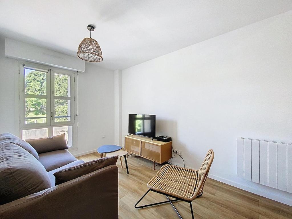 a living room with a couch and a tv at Appartement 4 personnes in Cholet