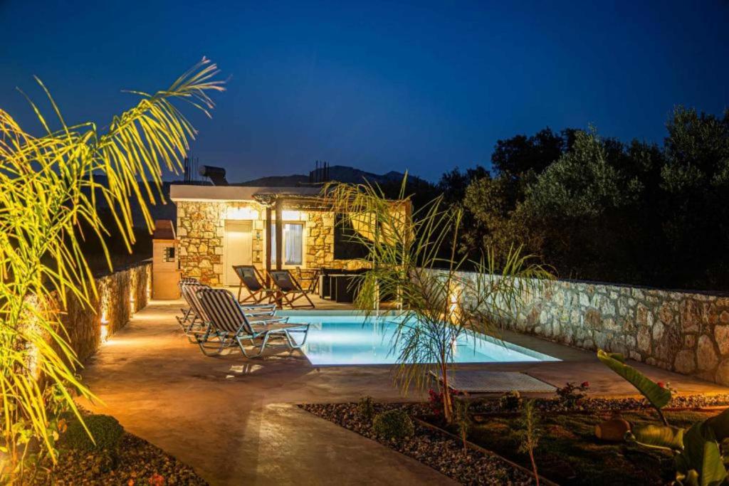 a villa with a swimming pool at night at Dreamy Charaki 2 Bd Villa with Private Pool in Haraki