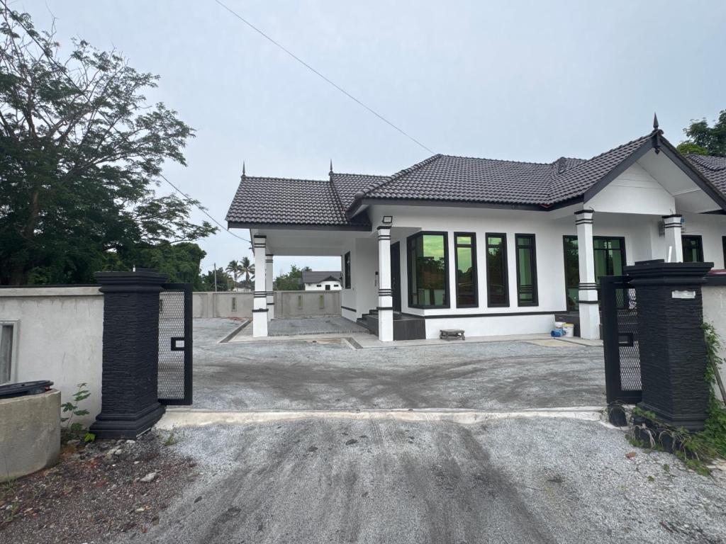 a house with a gate in front of it at HomestayDino in Kuala Terengganu