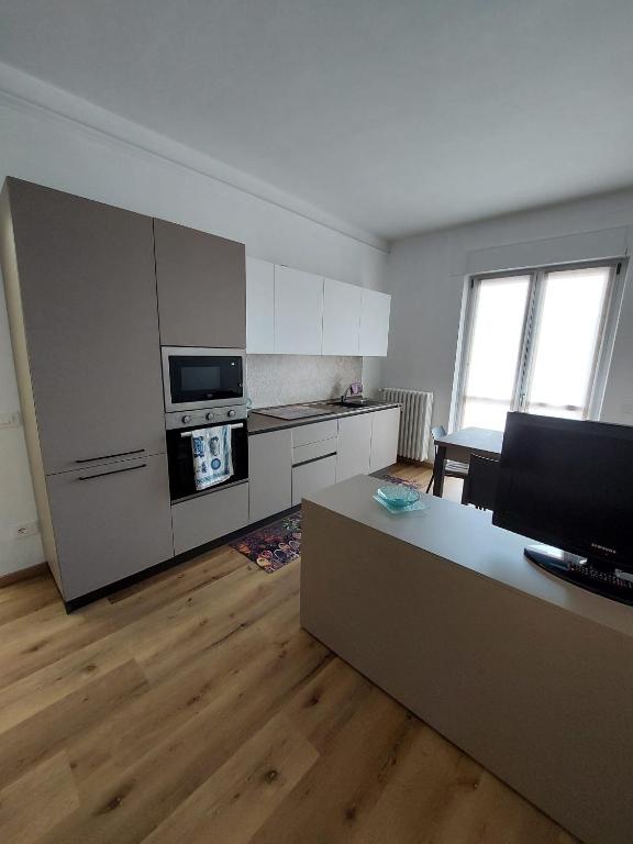 a kitchen with white cabinets and a living room at Il Lago di Luciana in Intra