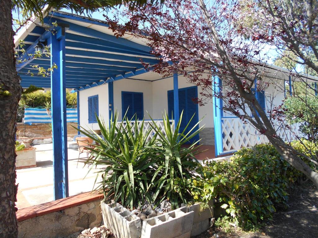 una casa con puertas azules y plantas delante de ella en Holiday home Riserva Marina Protetta, en Siracusa