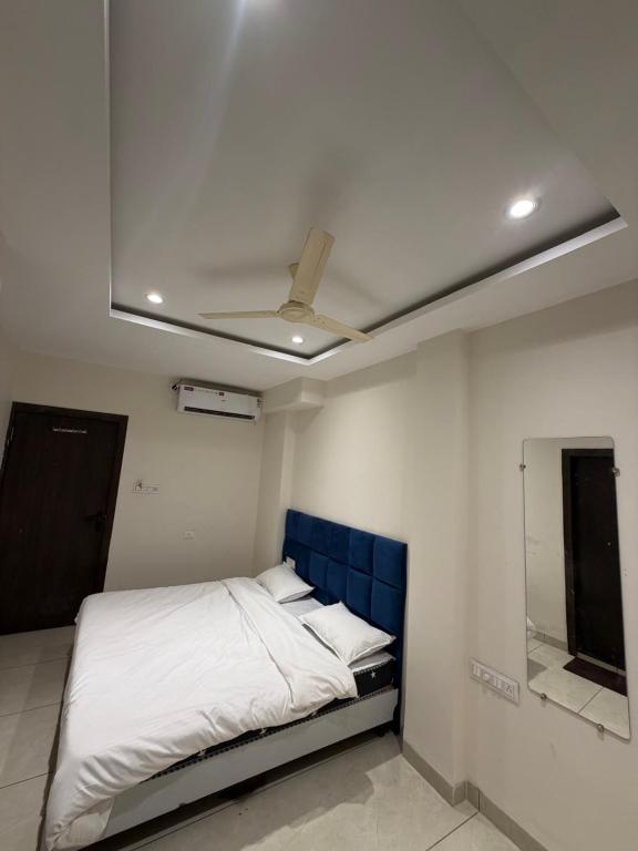 a bed in a room with a ceiling fan at Hotel Durga Palace in Ujjain