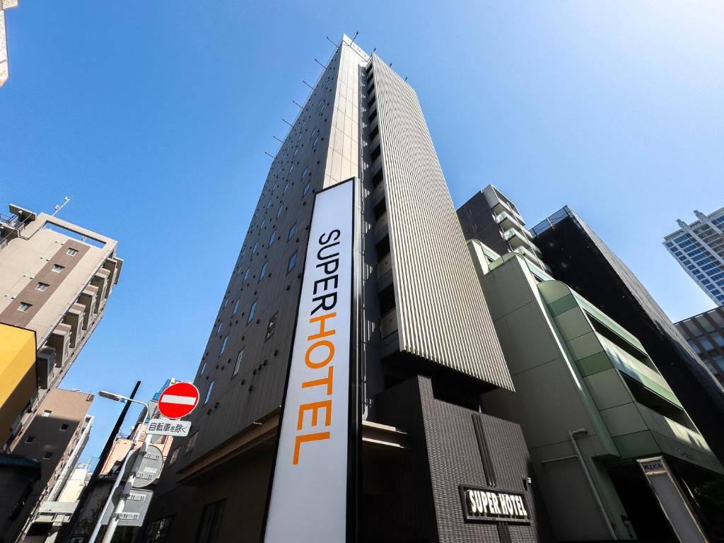a tall building with a sign in front of it at Super Hotel Akihabara Suehirocho in Tokyo