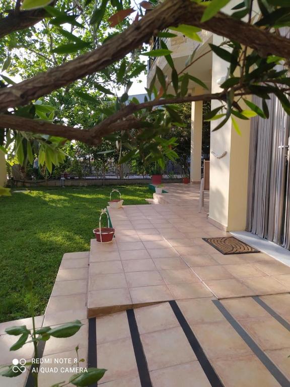 a garden with a stone walkway next to a building at Vicente Apartment in Skala Rachoniou