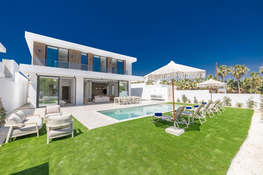 a house with a yard with chairs and a swimming pool at Ocean Whispers Villas in Paralimni